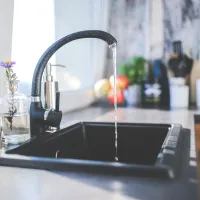 black kitchen faucet with running water. No sign of ants in this kitchen thanks to the exterminators at A-action Pest Control